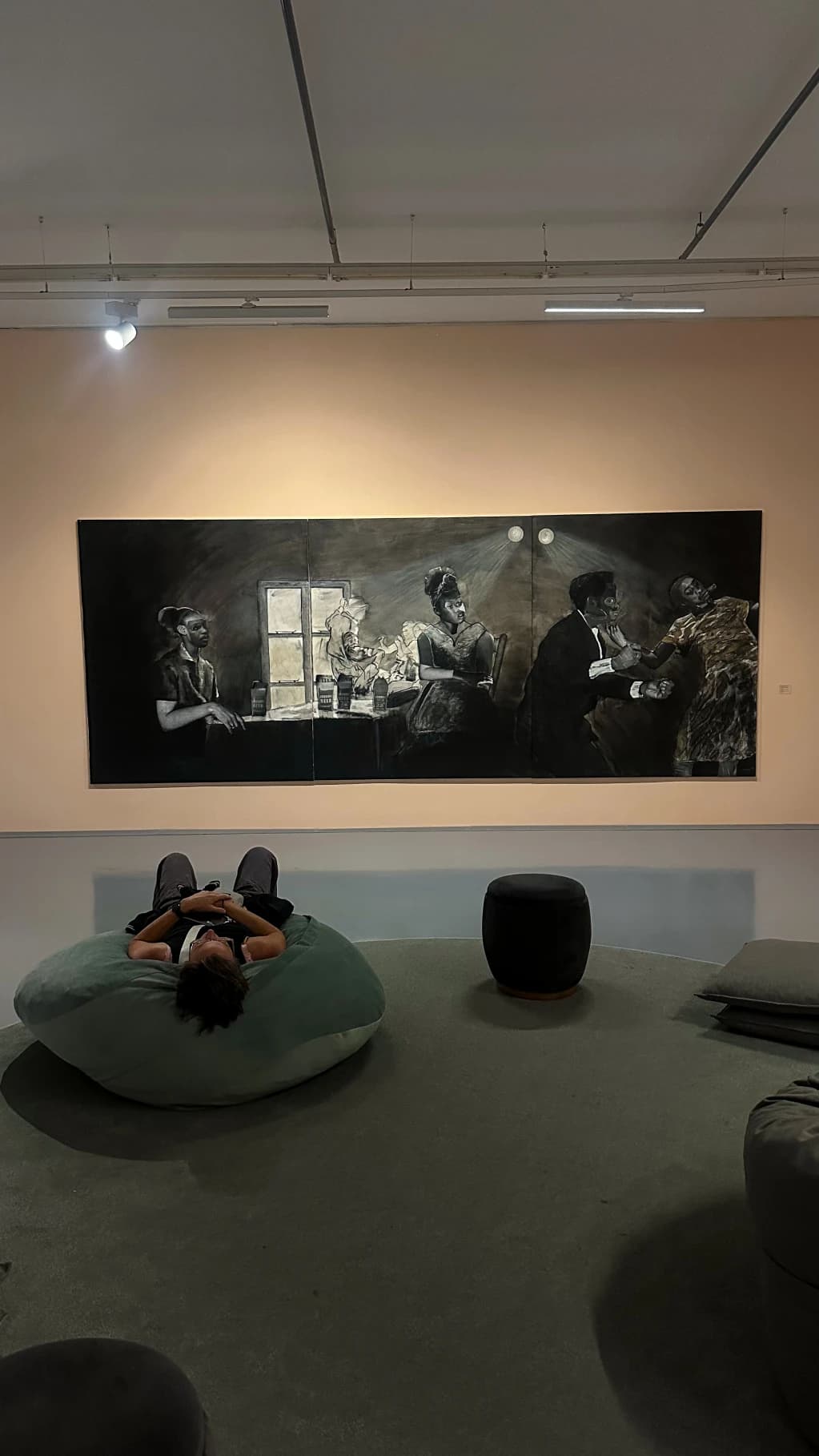 A visitor reclining in a quiet art gallery