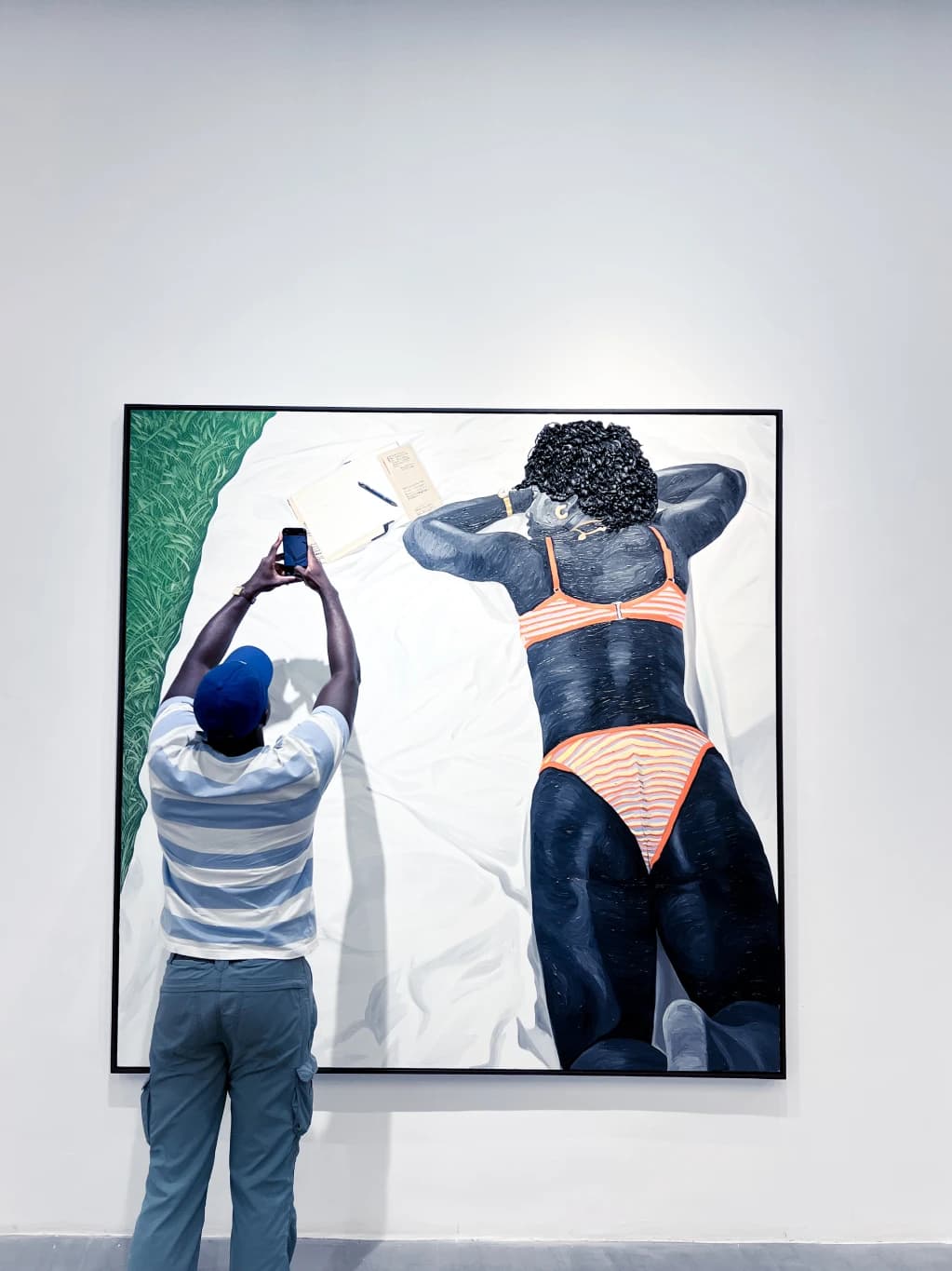 A visitor studying a painting in an art gallery