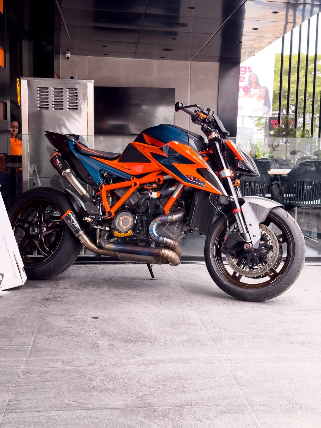 An orange motorcycle parked outside a workshop