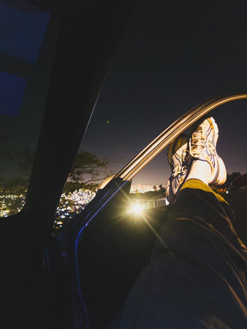 Sneakers resting above a city lit up at night